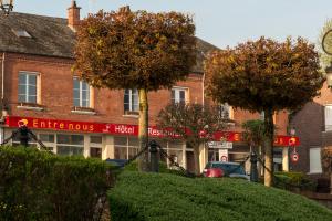a red brick building with trees in front of it at Entre Nous in Rozoy-sur-Serre