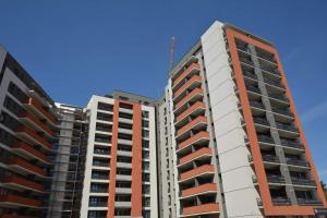 Armony Apartament Timisoara في تيميشوارا: عمارتين طويلتين مقابل السماء الزرقاء