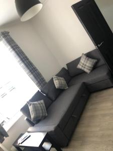 a black couch with pillows in a living room at City Centre Victorian Terrace in Cardiff