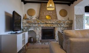 ein Wohnzimmer mit einem Steinkamin mit einer Couch in der Unterkunft Casa Hector in Granada