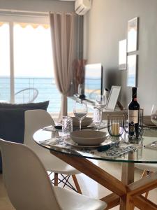 カラマタにあるSeafront Kalamata Haven - Blue Luxury Suiteのダイニングルームテーブル(ワイングラス付)