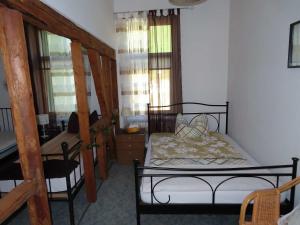 a bedroom with a bed and a desk and windows at Ferienwohnungen am Weinberg Bad Sulza in Bad Sulza