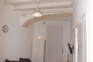 a room with a white wall and a ceiling with a clock at casa morola Monolocale in Trani