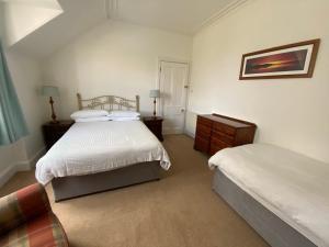 a bedroom with two beds and a dresser at Stanford House in Inverness