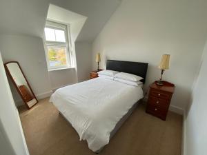 ein Schlafzimmer mit einem weißen Bett und einem Fenster in der Unterkunft Stanford House in Inverness
