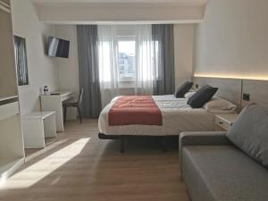 a hotel room with a bed and a couch at Seijo in Villalba