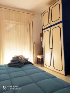 a bedroom with a blue bed and a window at Casa Cristina City in Comiso