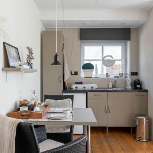 een keuken met een tafel met stoelen en een aanrecht bij d'Ouwe stal in Axel