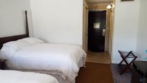 1 dormitorio con 2 camas y puerta que da a un pasillo en 2417 at Oceanfront Resort Lihue Kauai Beach Drive Private Condo en Lihue