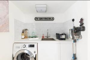 a kitchen with a washing machine and a sink at Cotswolds Lodge in Minster Lovell in Minster Lovell