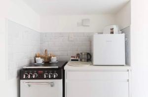 a kitchen with a stove and a white refrigerator at Cotswolds Lodge in Minster Lovell in Minster Lovell