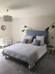 a bedroom with a large bed with pillows at La Lézardine in Ratenelle