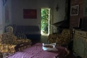 a living room with a table and a couch at Casa Charming immersa nel verde in Forte dei Marmi