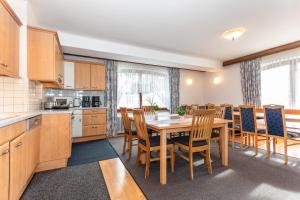 a kitchen and dining room with a table and chairs at Ferienhaus Alpenrose in Bruck an der Großglocknerstraße