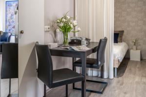 a table with two chairs and a vase of flowers at B&B De Kluis Axel in Axel
