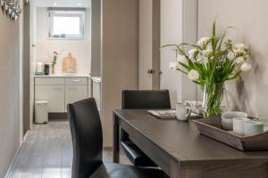 una mesa de comedor con sillas y un jarrón de flores en Suite 16, en Axel 6 fotos más
