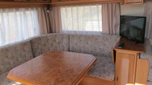 ein Wohnzimmer mit einem Sofa, einem TV und einem Tisch in der Unterkunft Am Wolfsbach 5 in Weitenhagen