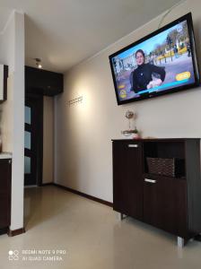 sala de estar con TV de pantalla plana en la pared en Leukozja, en Krynica Morska