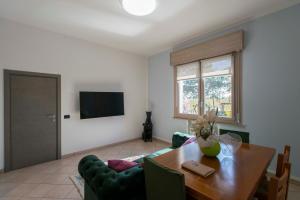 a living room with a dining room table and a television at Eco Dolce Casetta B&B in Faenza