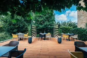- un ensemble de tables et de chaises sur une terrasse en bois dans l'établissement Pierre Hotel, à Pardubice