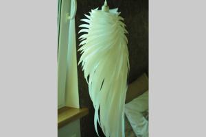 a feather hanging on a wall next to a bed at APARTAMENT Inspiracja in Mrągowo