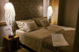 a bedroom with a large bed with two lights on it at APARTAMENT Inspiracja in Mrągowo