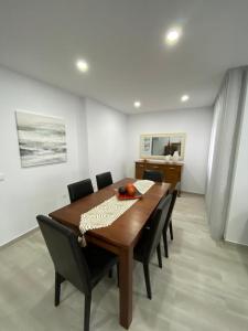 a dining room with a wooden table and chairs at Moradia Gina in Nazaré