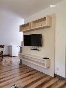a living room with a flat screen tv on a wall at Apartament Wolin nad wodą koło Miedzyzdrojów in Wolin