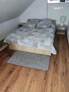 1 dormitorio con 1 cama y suelo de madera en Apartament Wolin nad wodą koło Miedzyzdrojów en Wolin
