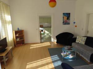 ein Wohnzimmer mit einem Sofa und einem Tisch in der Unterkunft Ferienwohnungen am Weinberg Bad Sulza in Bad Sulza