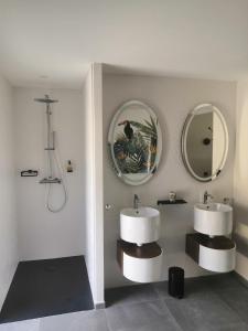 a bathroom with two sinks and a mirror at La Lézardine in Ratenelle