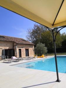 un grand parasol jaune au-dessus de la piscine dans l'établissement La Lézardine, à Ratenelle