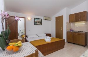 a room with a bed and a table with fruit on it at Apartments Erceg in Makarska