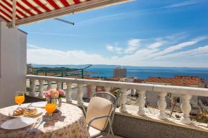 a table and chairs on a balcony with a view at Apartments Erceg in Makarska