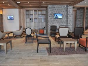 a living room with chairs and tables and a wall at The Nest Apartman, Župa Wellness & Spa Kopaonik in Kopaonik