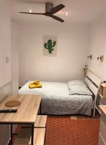 ein kleines Schlafzimmer mit einem Bett und einem Tisch in der Unterkunft Accostage Vieux-Port - Appartements & Parking in La Ciotat