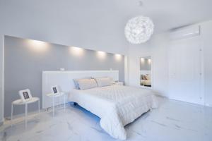 una camera bianca con un letto bianco e due tavoli di New Central Apartment & Rooms a Montecatini Terme