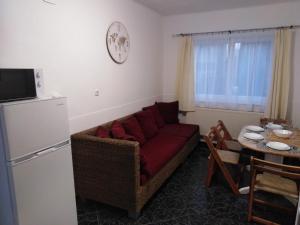 ein Wohnzimmer mit einem Sofa und einem Tisch in der Unterkunft Arinza Apartman Vendégház in Mezőkövesd