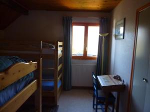 een slaapkamer met een stapelbed, een bureau en een raam bij Gîte des Gorges du Bruyant in Saint-Nizier-du-Moucherotte