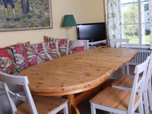 uma mesa de jantar em madeira com cadeiras e um sofá em Gripsholms BnB em Mariefred