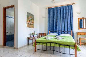 a bedroom with a bed with a blue shower curtain at Des Roses Hotel in Platanias
