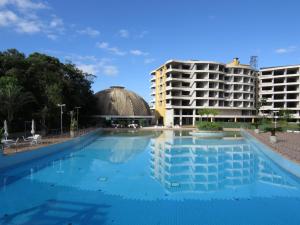 a large swimming pool in front of a hotel at Casa de campo em resort com banheiras água termal in Santo Amaro da Imperatriz