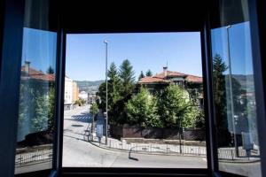ein Fenster mit Blick auf eine Straße und ein Gebäude in der Unterkunft EL BALCÓN DE CAMPO LOS PATOS in Oviedo