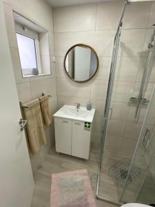 a bathroom with a shower and a sink and a mirror at Gina House in Nazaré