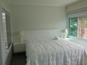 - un lit blanc dans une chambre avec fenêtre dans l'établissement Casa de campo em resort com banheiras água termal, à Santo Amaro da Imperatriz