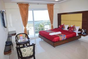 a bedroom with a red bed and a large window at B2B Home Stay in Kodaikānāl +83 photos