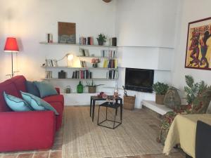 a living room with a red couch and a tv at Domaine Sesquier Mas d'exception Jasmin in Mèze