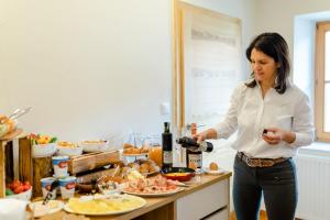 a woman standing in a kitchen holding a bottle of wine at Gästezimmer Das Hambammer in Heimschuh