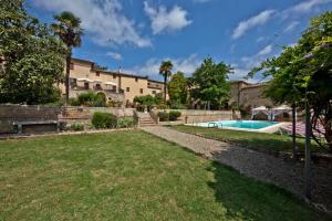 een achtertuin met een zwembad en een huis bij Villa La Consuma : casa storica in paese, giardino, piscina, WiFi in San Giovanni dʼAsso