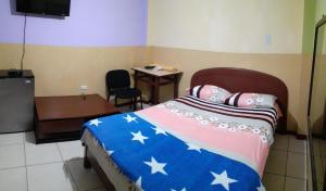 a bedroom with a bed and a table and a chair at Hostal Jovita in Lima